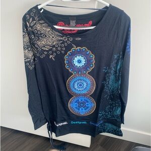Desigual brand. Blue long sleeve blouse with design on front.